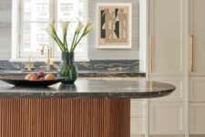 a sophisticated neutral kitchen with shaker cabinets, a stained fluted and curved kitchen island, black marble countertops