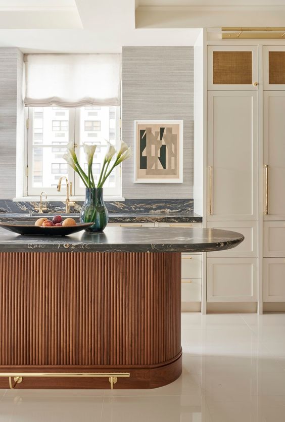 a sophisticated neutral kitchen with shaker cabinets, a stained fluted and curved kitchen island, black marble countertops