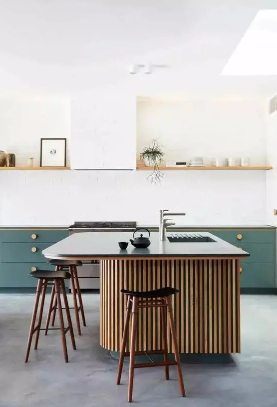 a stylish kitchen with green cabinetry, an open shelf instead of upper cabinets, a large fluted kitchen island with a black countertop and black stools