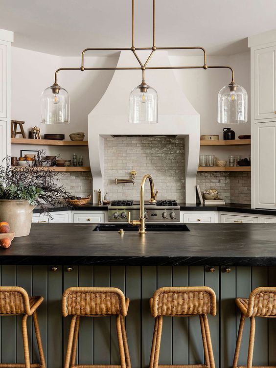 a stylish kitchen with white cabinetry, a slate grey kitchen island, black countertops, open shelves and a glossy tile backsplash
