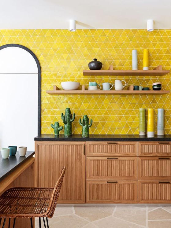 a stylish mid-century modern kitchen with wooden cabinets and furniture, black countertops and a lemon yellow tile backsplash