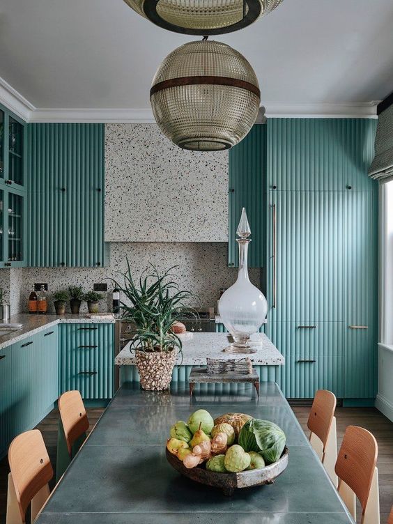 a turquoise fluted kitchen with white terrazzo on the backsplash and countertops plus black fixtures