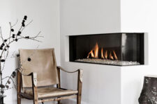 a welcoming Scandinavian space with a built-in corner fireplace, a leather and wood chair, a skin rug and some wild decor