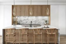 a white minimalist kitchen with fluted upper cabinets, a white marble backsplash, a fluted kitchen island with a white marble countertops and tall stools