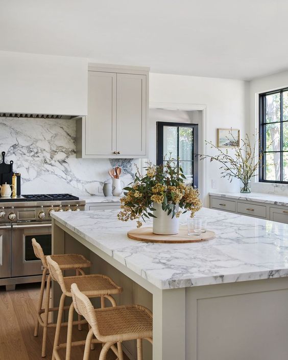 an airy greige kitchen with a white quartz backsplash and matching countertops that elevate the look of the space