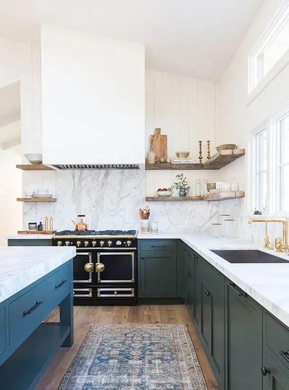 an elegant dark green kitchen with shaker cabinets, a large white hood, a white quartz backsplash and countertops
