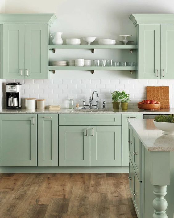 a beautiful farmhouse kitchen in mint green, with shaker cabinets, open shelves, white subway tiles and vintage fixtures