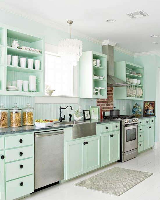 a cottage mint green kitchen with shaker cabinets, dark terrazzo countertops and a beadboard backsplash, black fixtures