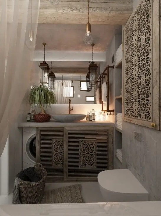a neutral Moroccan bathroom with a vanity with sliding ornated doors that hide a washing machine, a mirror and an ornated screen