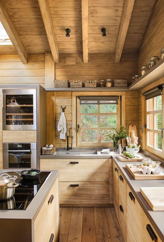 a contemporary chalet kitchen with sleek cabinets, concrete countertops, black touches and skylights for more natural light
