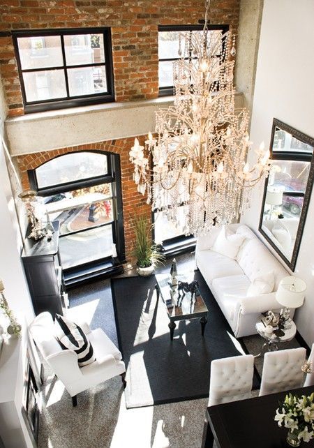 a small glam living room with two rows of windows, white seating furniture, a black coffee table and a black storage unit