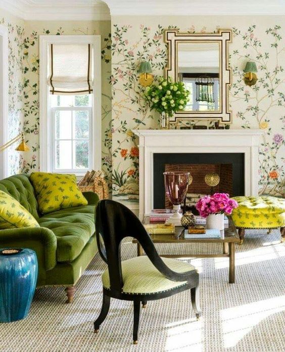 a vintage living room with floral wallpaper, a green sofa and yellow pillows, a coffee table and a yellow chair