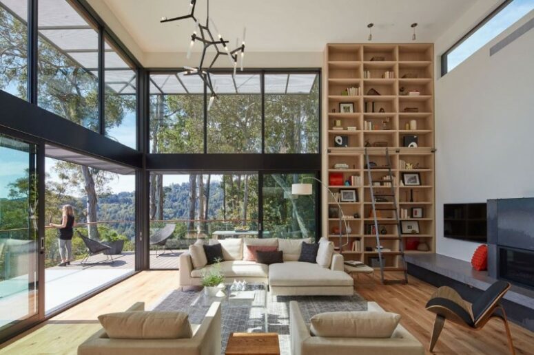 a welcoming living room with glazed walls, neutral seating furniture, a black chair, a TV and a TV unit, a tall bookcase with a ladder