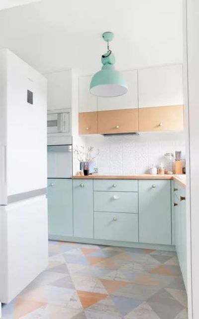 an airy Scandinavian kitchen with stained and mint blue cabinets, a white tile backsplash and a geometric floor plus a mint pendant lamp