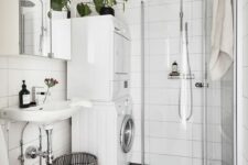 27 a black and white Scandinavian bathroom with white and black tiles, a shower in the corner, a washing machine and a dryer and a sink
