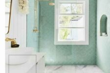 29 a chic bathroom clad with mint herringbone tiles and marbles ones, a white floating vanity, gold fixtures and natural light