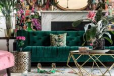 a bright living room with a whimsical wallpaper accent wall and a fireplace an emerald sofa, a pink chair, a gold base coffee table and a floral rug