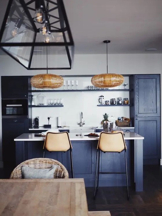 a cool contemporary navy kitchen with white countertops and a backsplash, rattan lamps and leather stools