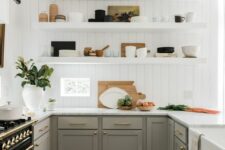 31 a grey farmhouse kitchen with shaker cabinets, a white beadboard backsplash, open shelves and white countertops plus black sconces