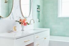 32 a chic bathroom with mint subway tiles in the bathtub space, a white vanity, a pink pouf and some gold touches for a more glam look