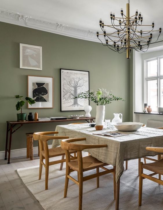 ديكورات مودرن 35-a-beautiful-modern-dining-room-with-a-sage-green-accent-wall-a-table-and-wooden-chairs-a-console-table-with-some-decor-and-a-gallery-wall