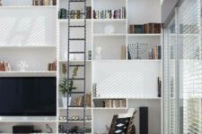38 a contemporary living room with a large bookcase that takes a whole wall, neutral seating furniture and a tall ladder is amazing