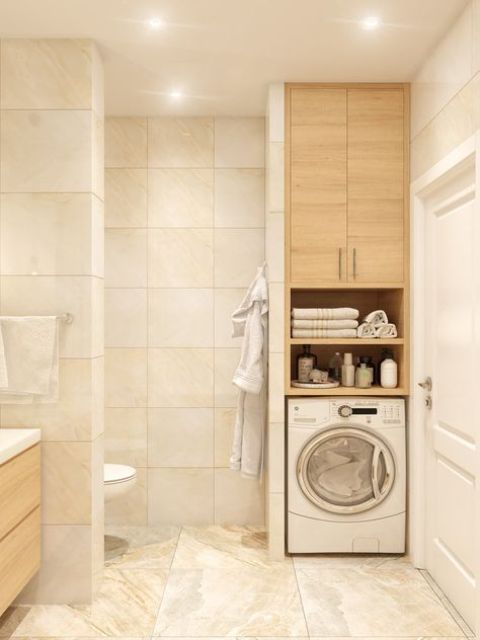 a warm-colored beige bathroom with large square tiles, a built-in washing machine and a cabinet, a vanity