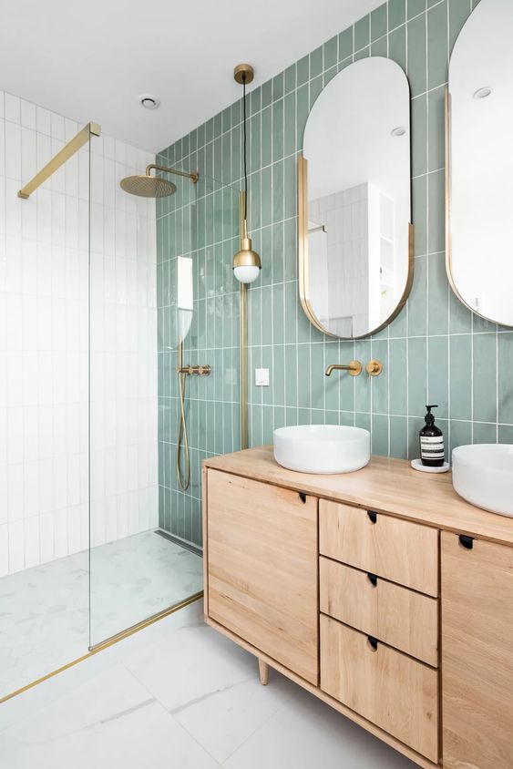 ديكورات مودرن 45-a-modern-bathroom-with-a-sage-green-tile-wall-a-stained-vanity-oval-mirrors-and-round-sinks-a-shower-space-enclosed-in-glass