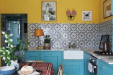 54 a bright kitchen with yellow walls, blue cabinets, a stone countertops and a beautiful printed tile backsplash for a bolder touch