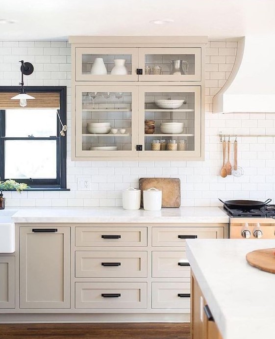 a beautiful light stained shaker style kitchen with a white subway tile backsplash and white quartz countertops plus black fixtures