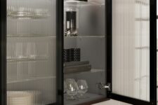 a black kitchen with fluted glass cabinets and lights inside that are great to display dishes and glasses is a chic idea