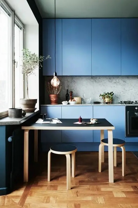 a blue minimalist kitchen with a grey marble backsplash and a black dining set for a gorgeous look
