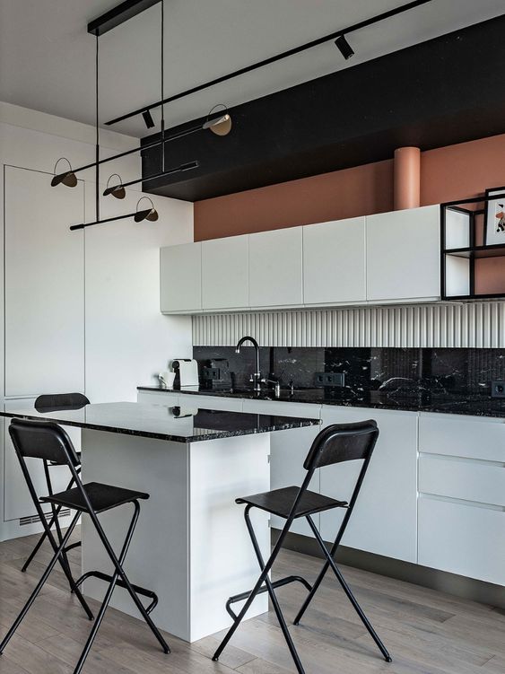 a bold and contrasting black and white kitchen with flat panel cabinets, a black tile backsplash, a small kitchen island that doubles as a dining table