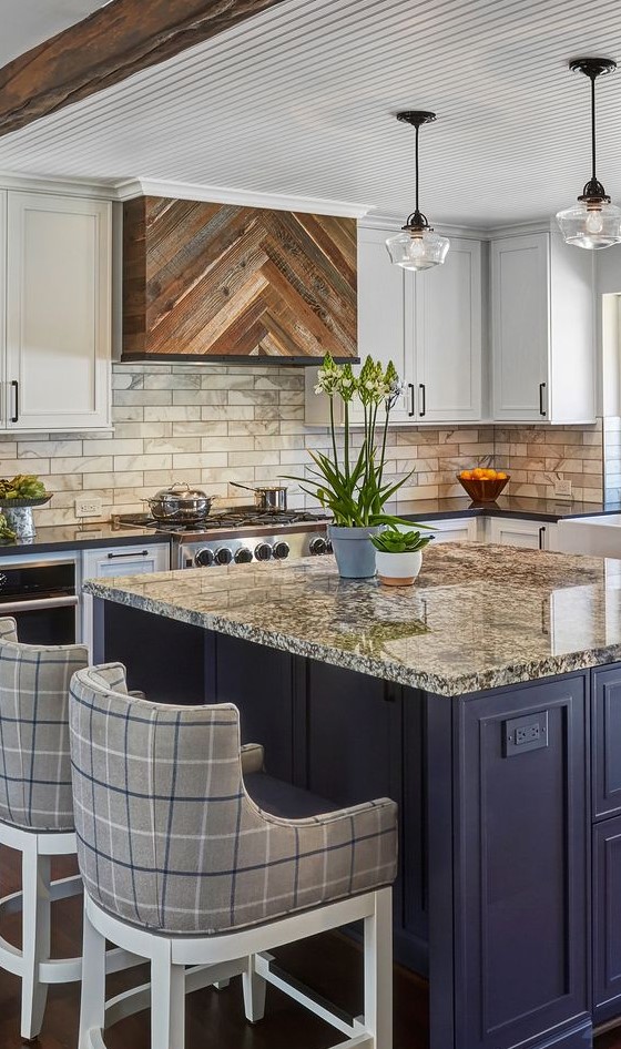 a bold kitchen with white cabinets, a navy kitchen island, a marble tile backsplash and granite countertops plus plaid stools