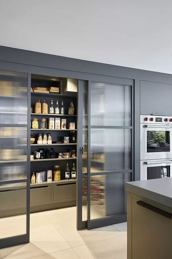 a built-in pantry with fluted glass sliding doors and built-in lights is a lovely space to store all you need and it will give an edge to your kitchen