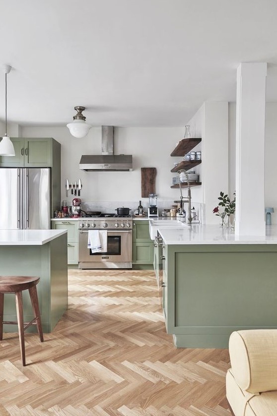 a chic contemporary kitchen in sage green and white, with dark wooden touches and white countertops is very welcoming