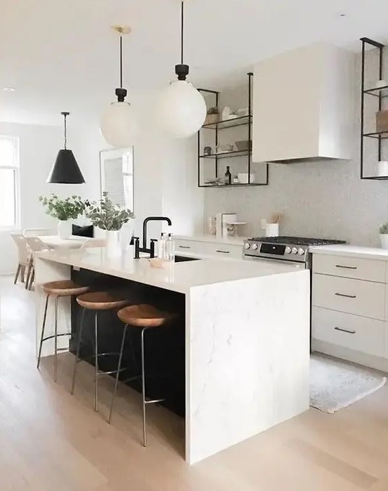 a chic contemporary kitchen with elegant white cabinets, a white tile backsplash, a black kitchen island with a white stone countertop and pendant lamps