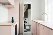a chic girlish kitchen with simple blush plywood cabinets and a grey tiled floor flooded with much natural light