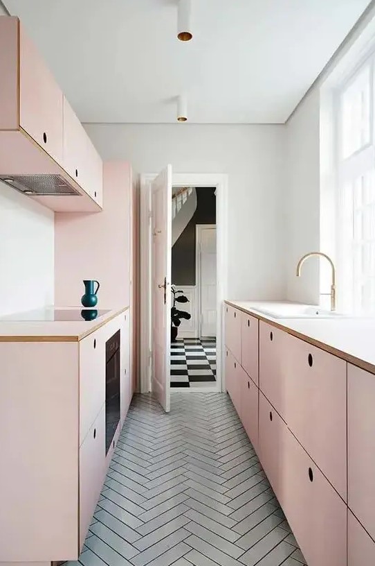 a chic girlish kitchen with simple blush plywood cabinets and a grey tiled floor flooded with much natural light