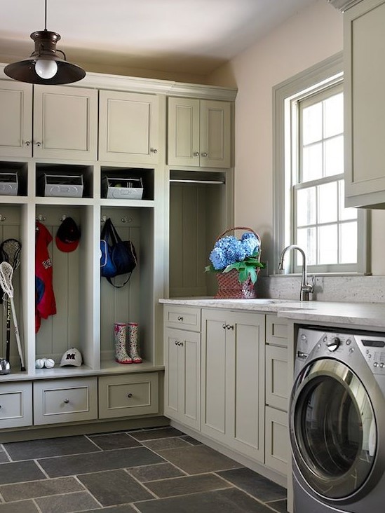 a greige mudroom laundry with shaker cabinets and an open storage unit, a washing machine and a dryer and white stone countertops