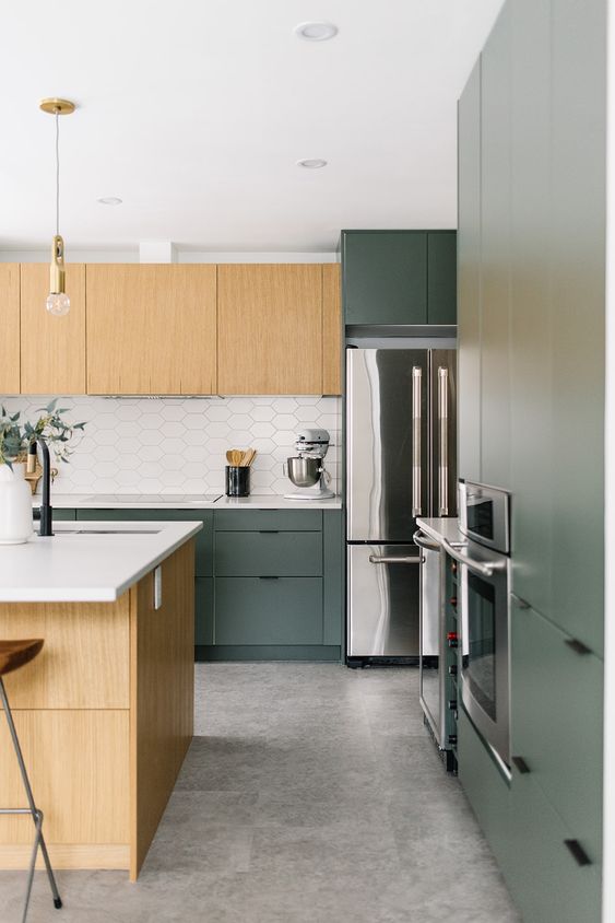 a lovely modern kitchen with light-stained and green flat panel cabinets, a white hex tile backsplash and a large kitchen island