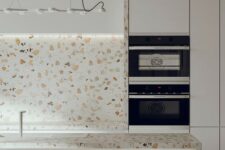 a minimalist white kitchen with cool white terrazzo countertops and a backsplash plus a pendant lamp is amazing