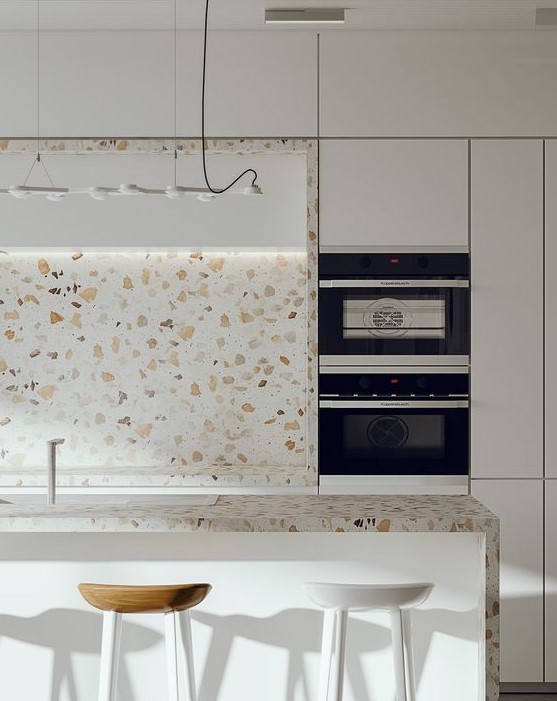 a minimalist white kitchen with cool white terrazzo countertops and a backsplash plus a pendant lamp is amazing