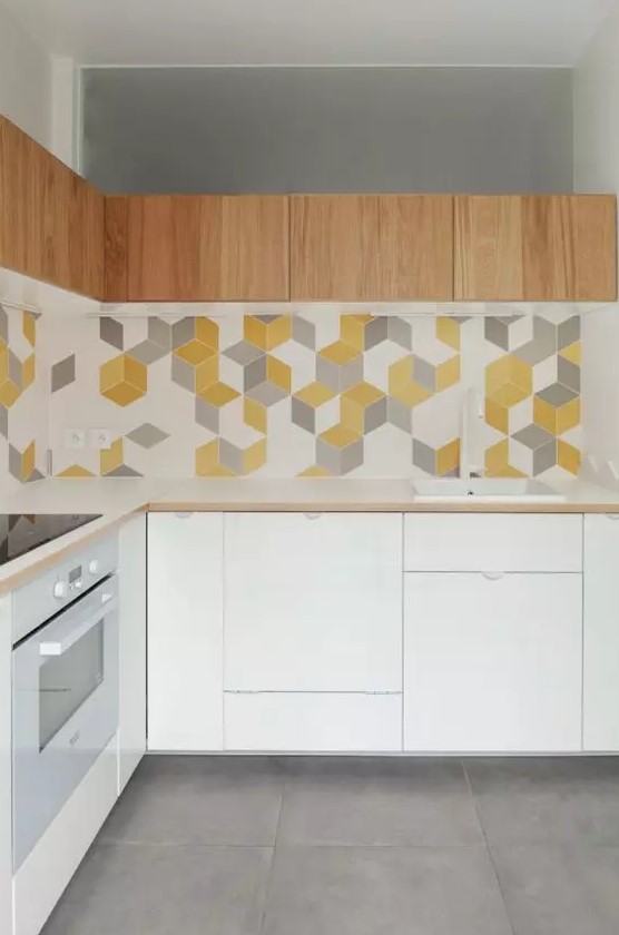 a minimalist white kitchen with sleek cabinets, white countertops, a bright geo tile backsplash and light-stained upper cabinets