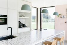a modern and serene kitchen with white flat panel cabinets, a white kitchen island with a white terrazzo countertop