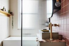 a modern bathroom with dusty pink tiles and grey ones, a graphic rug, a bathtub and a reeded glass space divider and a large mirror