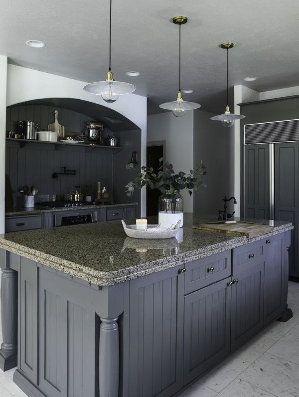 a modern cottage kitchen in charcoal grey, with slatted cabinets, a niche with a cooker and grey granite countertops