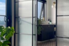 a modern space with fluted glass framed sliding doors to the bathroom that look airy and still divide the space very well