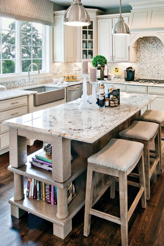 a neutral farmhouse kitchen with shaker cabinets, a vintage whitewashed kitchen island, white granite countertops and a backsplash