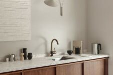 a pretty rustic minimalist kitchen with stained cabinetry and grey terrazzo countertops is a lovely and welcoming space